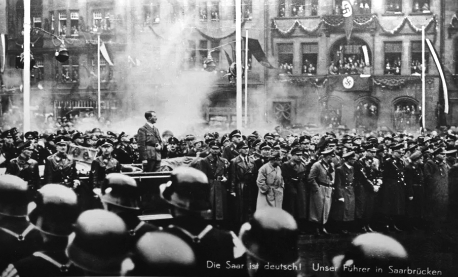 Adolf Hitler salutes the parade in front of the town hall in Saarbrücken, to celebrate the reintegration of the Saarland in the German Reich